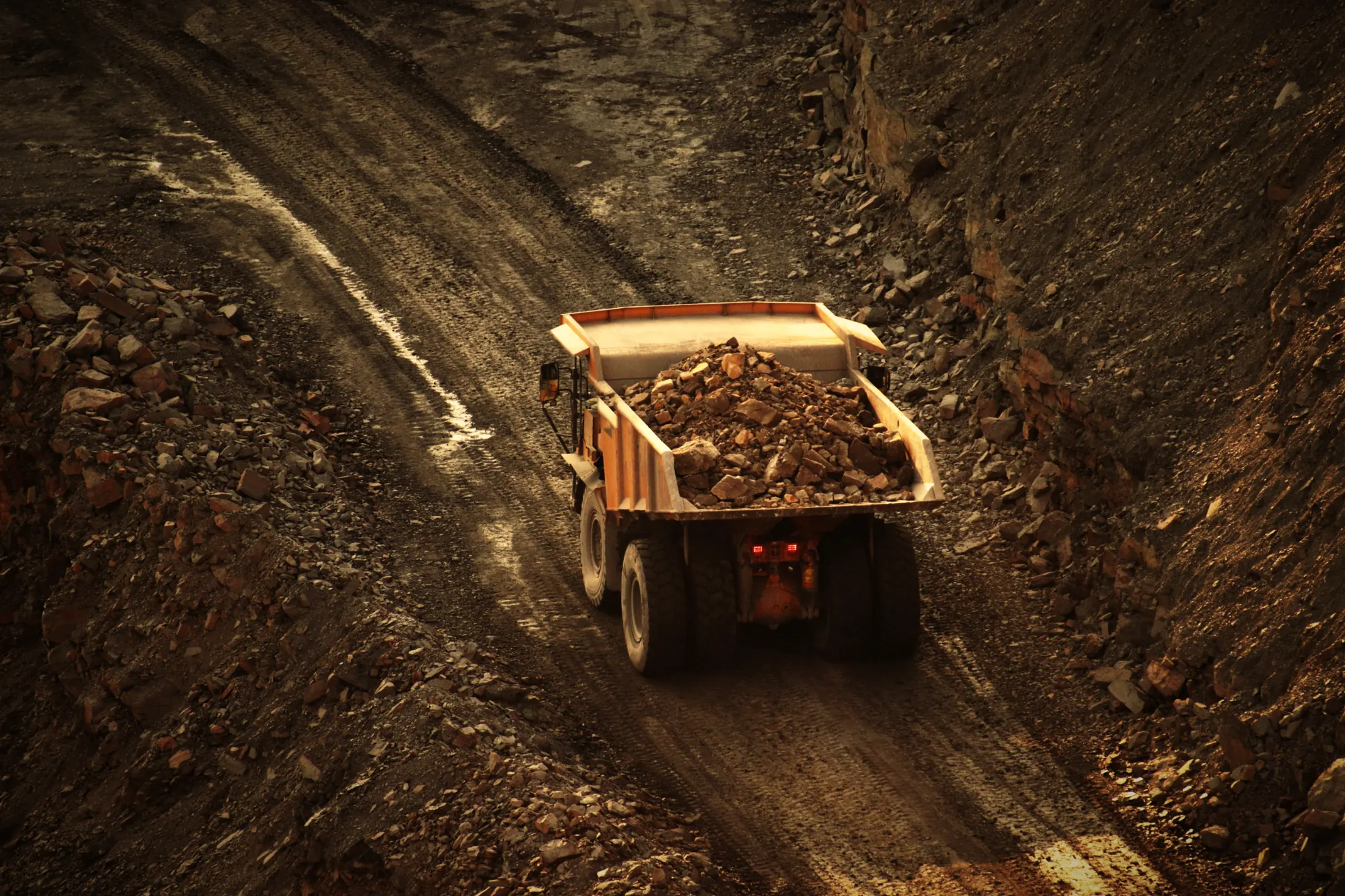 Loaded haul truck climbing a ramp road inside an open-pit mine